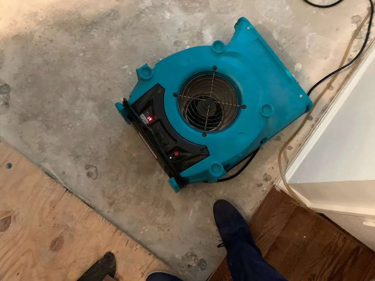 Air mover drying subfloor during Commercial Water Damage Restoration in Wharton
